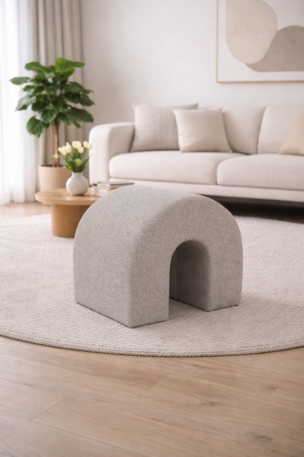 An elegant ivory boucle curved ottoman bench positioned in a modern hotel lobby, showcasing organic furniture design trends.