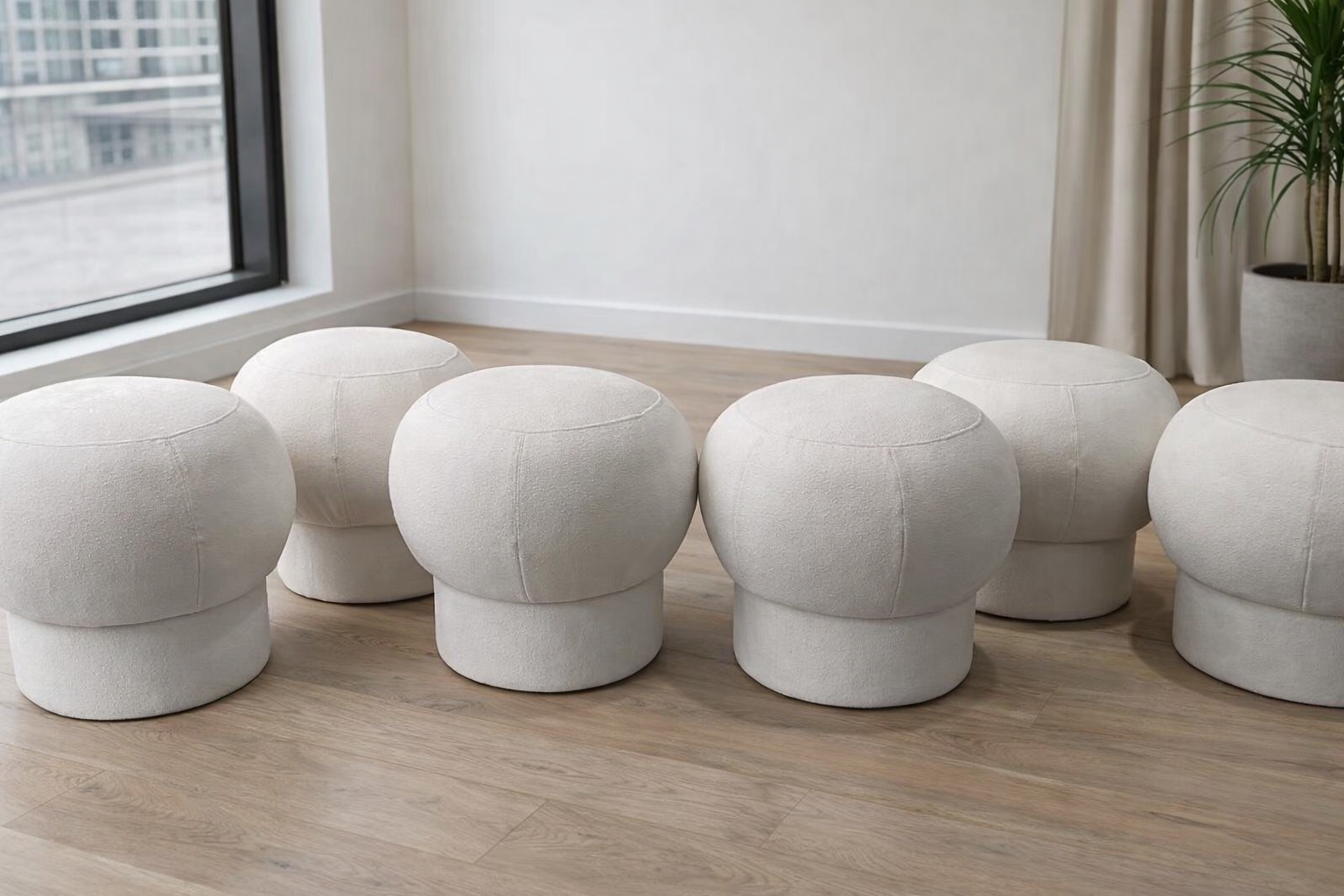 A collection of organic-shaped mushroom ottoman stools in various velvet colors, showcasing biomorphic furniture trends for 2026.