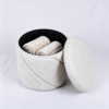 Open lid showing inside storage space of white textured fabric ottoman