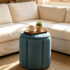Blue Pleated Linen Ottoman Footstool in Modern Living Room Close-up of blue pleated linen fabric texture on round storage ottoman