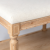 Cream tufted rectangular footstool bench featuring solid wood frame and open lower storage tier
