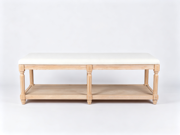 Beige upholstered rectangular ottoman coffee table featuring carved wooden legs and a bottom storage shelf.