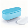 Light blue velvet oval storage ottoman with gold metal legs, shown on a white background with top lid turned over as a serving tray holding coffee cups.