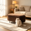 Brown velvet oval footstool placed in front of a neutral sofa as a comfortable footrest