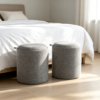 Close-up view of the minimalist leather accent handle on a grey round fabric storage ottoman